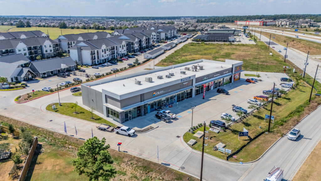 Aerial view of a Houston strip center photographed for commercial leasing, showing surrounding businesses and peak traffic visibility.
