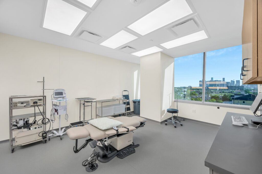 Modern medical exam room with treatment table and equipment, photographed by Patrick Bertolino in Houston, Texas.