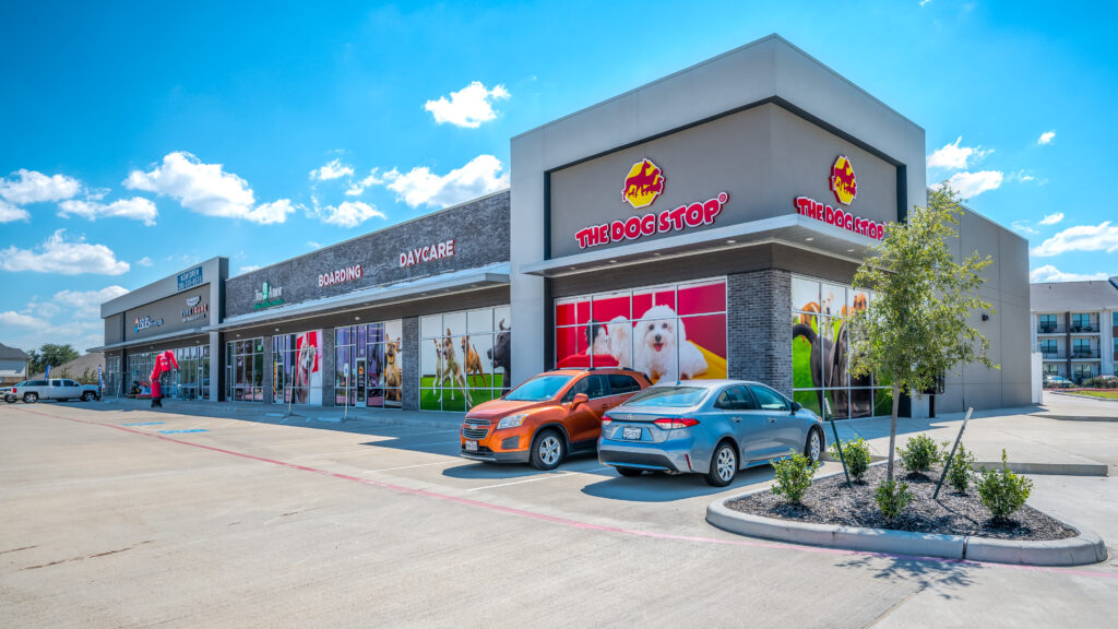 Ground-level view of a Houston strip center featuring retail storefronts, photographed for commercial leasing and marketing.